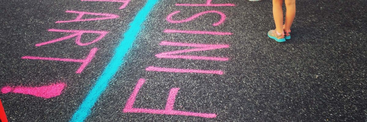 girls writing on the asphalt with chalk